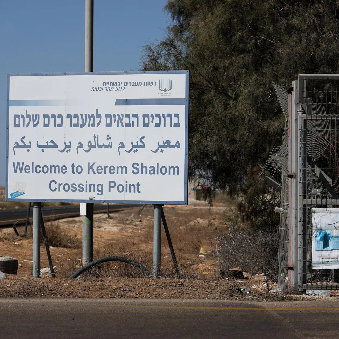 A view shows a sign as trucks carrying aid (not pictured) wait at the Israeli side of the Kerem Shalom border crossing to southern Gaza in southern Israel, October 20, 2025. REUTERS/Hannah McKay/File Photo