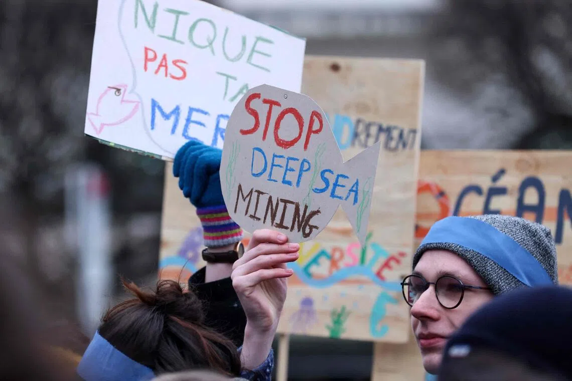 Activists take part at a "Look Down action" rally to stop deep sea mining outside the European Parliament, in Brussels, in 2023.