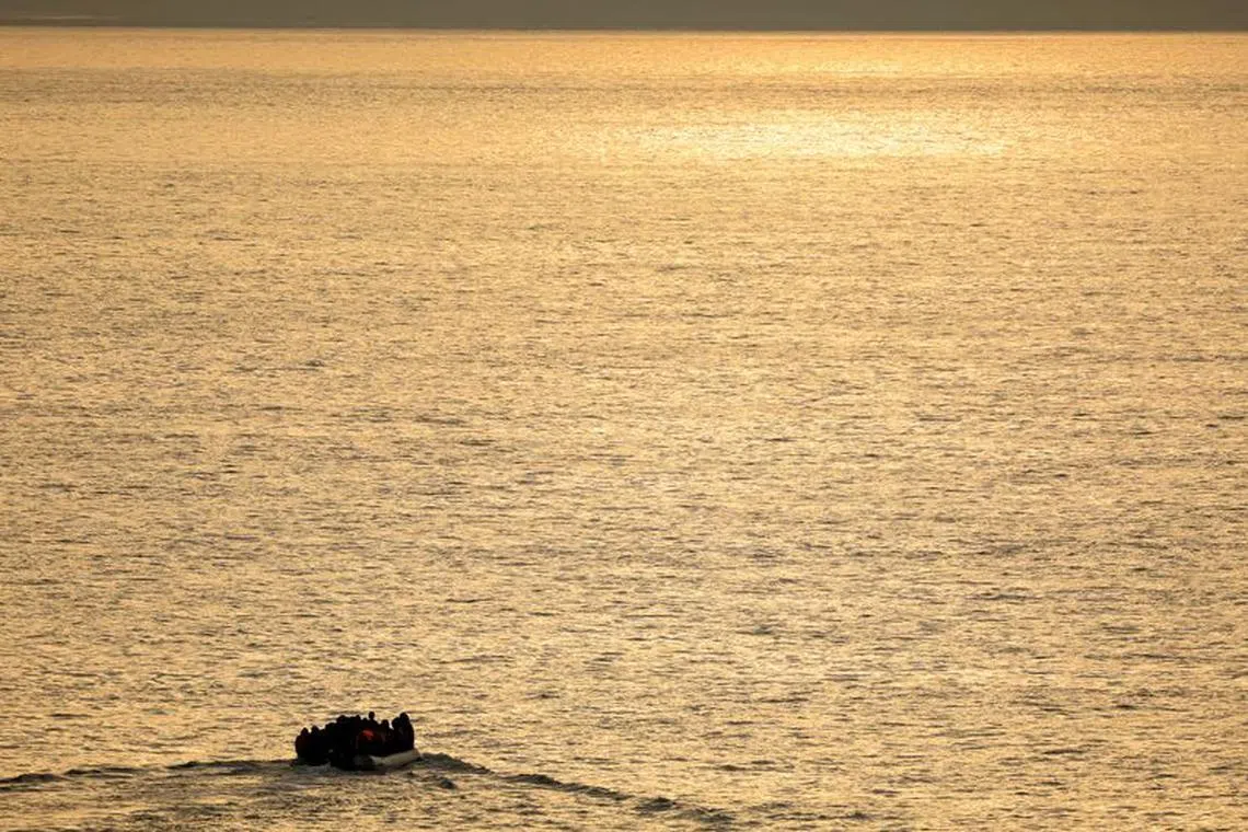 FILE PHOTO: A group of migrants on an inflatable dinghy is seen during sunrise from the French rescue vessel \"Abeille Normandie\" as they try to cross the English Channel from the coast of northern France, as warm weather and calm seas are favourable for crossings, France, October 2, 2023. REUTERS/Pascal Rossignol/File Photo