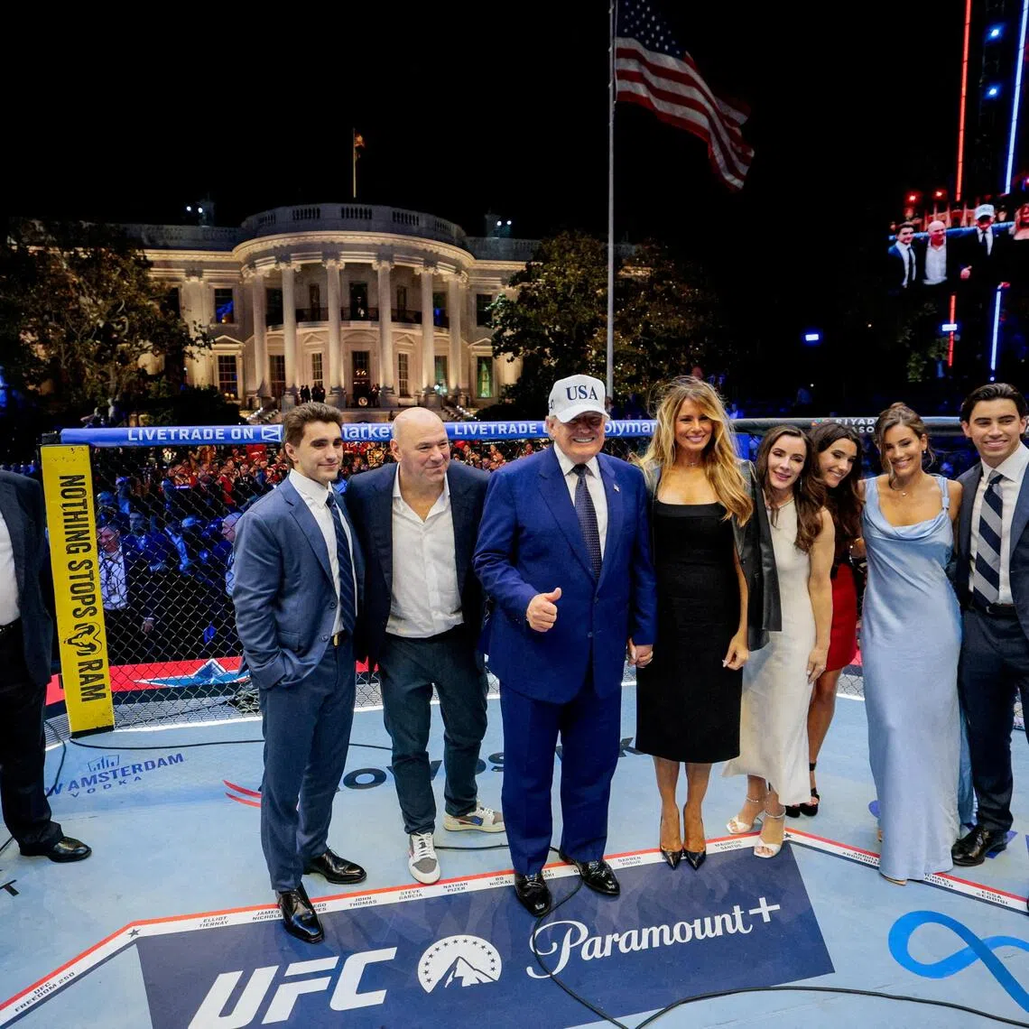 US President Donald Trump (centre), First Lady Melania Trump (fourth from left), UFC CEO Dana White (second from left) and other guests pose inside the Octagon at UFC Freedom 250 on the South Lawn of the White House on June 15.