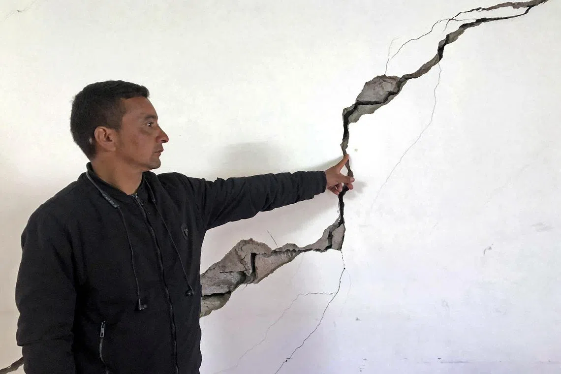 A resident shows a crack on the wall of his house at Joshimath in Chamoli district of India's Uttarakhand state on January 8, 2023. - Hundreds of panicked residents in one of India’s holiest Himalayan towns in the north were being relocated to safe places after many homes, hotels and roads developed wide cracks and started sinking, officials said on January 8. (Photo by AFP)