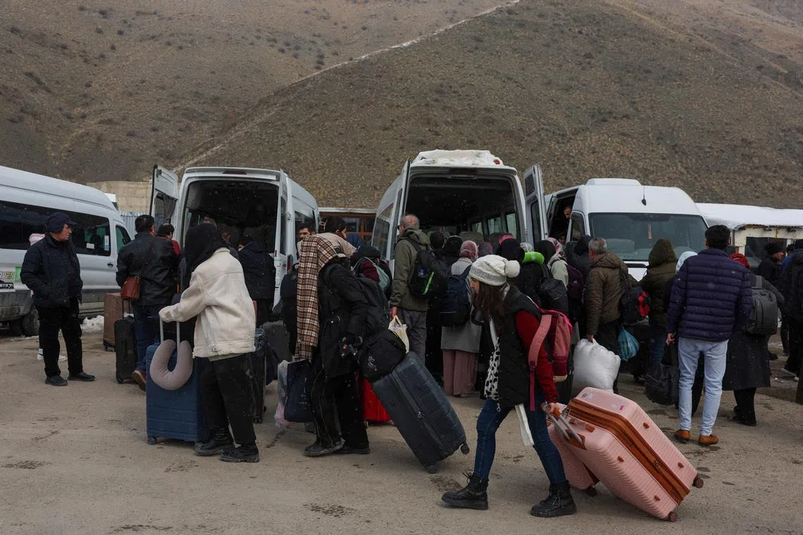 People wait for transportation to the city center after crossing from Iran into Turkey at the Kapikoy Border Gate in eastern Van province, Turkey, March 2, 2026. REUTERS/Dilara Senkaya