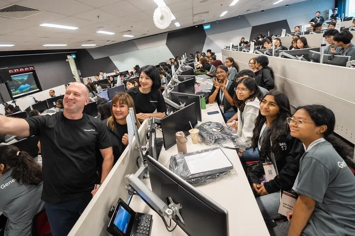 (De gauche à droite) Denver Scott de JP Morgan Chase, Eileen Lim de JP Morgan Chase et Son Xue Ling, ministre principal des Transports et du Développement national, prennent un selfie avec les participants pendant une pause du programme. 