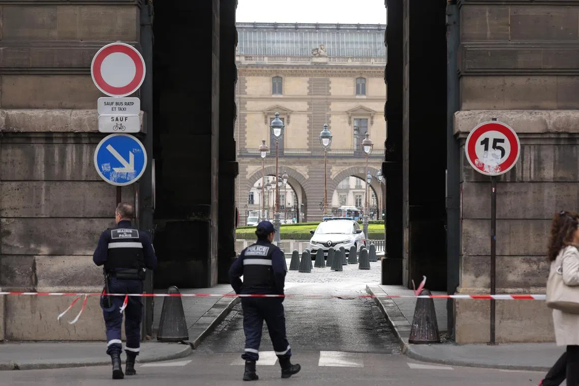 Police stand in a cordoned-off area near the Louvre Museum in Paris on Saturday, after it was evacuated  following a reported bomb threat. 