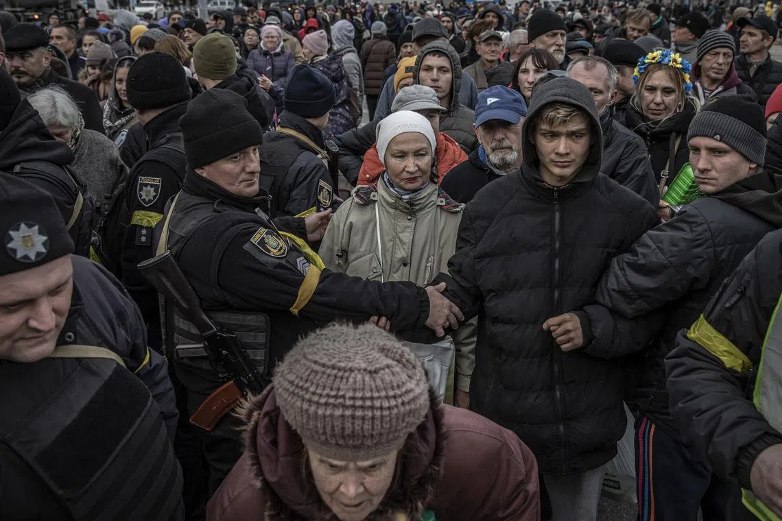 Crowds gather for food distribution in Kherson, Ukraine, Nov. 19, 2022. As winter approaches, Ukraine’s government is planning to help residents leave the recaptured southern city of Kherson, where Russian soldiers blew up and tore down critical infrastructure before their recent retreat, cutting off supplies of running water, heat and electricity. (Finbarr O'Reilly/The New York Times)