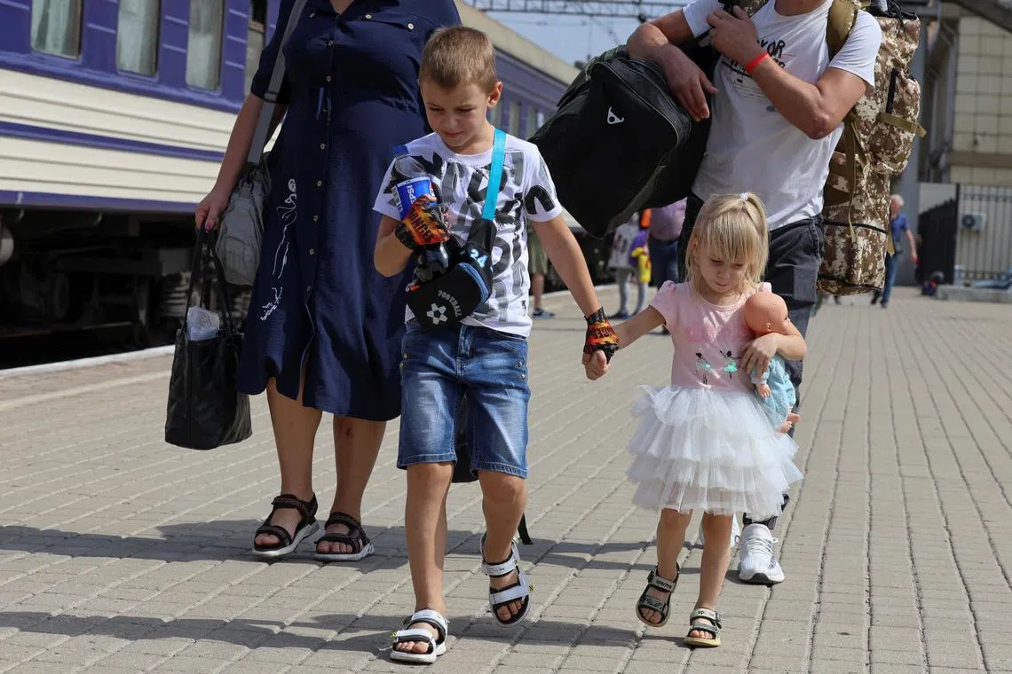 A family at the railway station in Pokrovsk heading to board an evacuation train to Western Ukraine, on Aug 30.