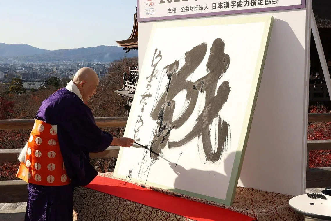 Seihan Mori, master of the ancient Kiyomizu temple, writes the Chinese character, known in Japan as "kanji", for 'war', which was selected as the single best kanji to symbolise the year of 2022 at a temple in Kyoto on December 12, 2022. (Photo by JIJI PRESS / AFP) / Japan OUT