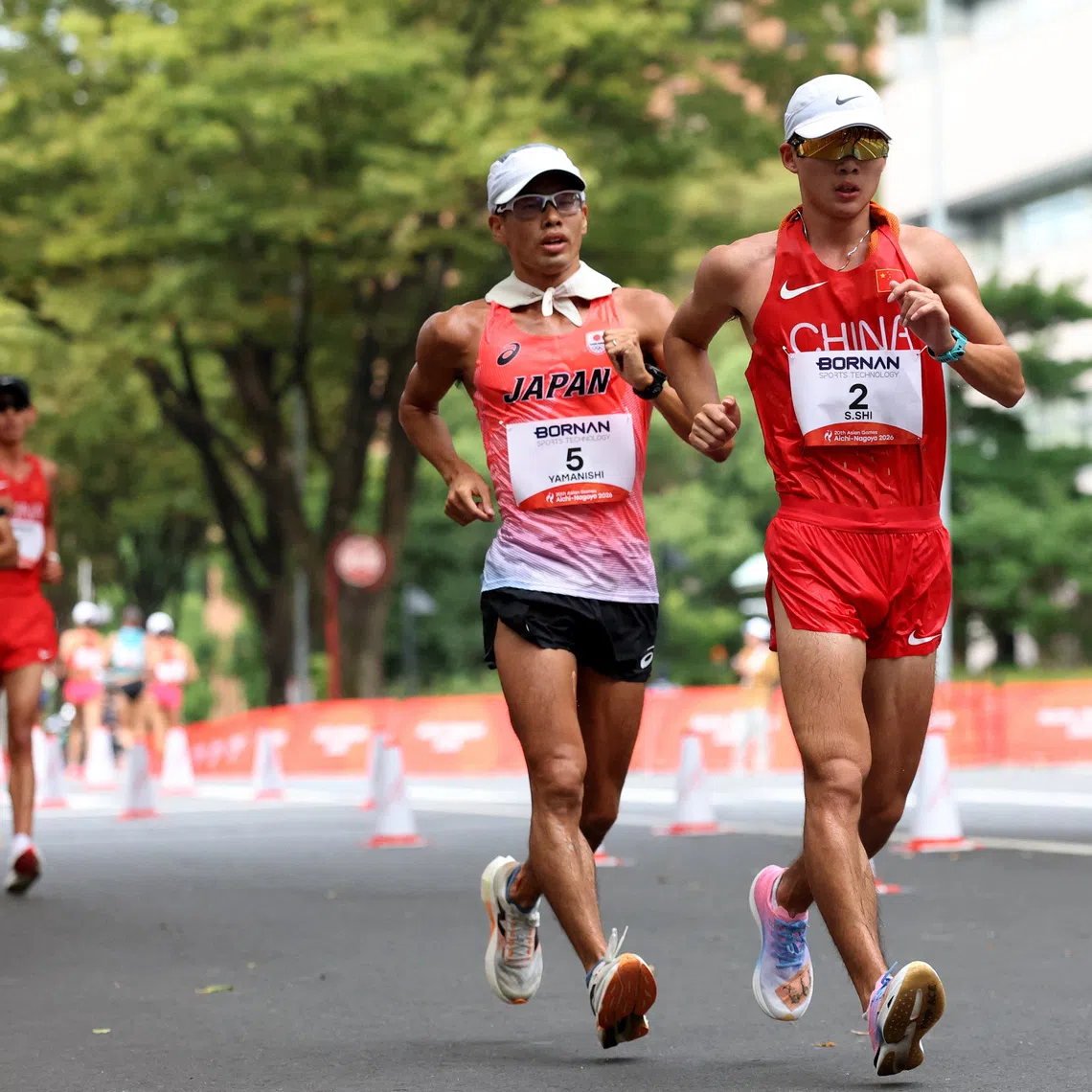 Asian Games - Aichi-Nagoya 2026 - Race Walk - Aichi Prefectural Government Office and Nagoya City Hall Loop Course, Nagoya, Japan - September 23, 2026 Japan's Toshikazu Yamanishi and China's Shengji Shi in action during the men's half marathon race walk REUTERS/Andrew Boyers