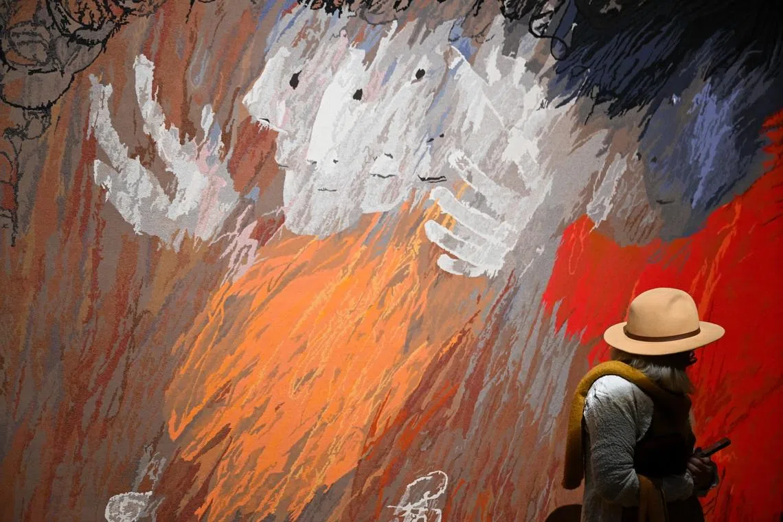 A guest viewing a tapestry during a media preview of the major winter exhibition Arthur Boyd: Tapestries at the National Gallery of Australia in Canberra, Australia, June 18, 2026. 