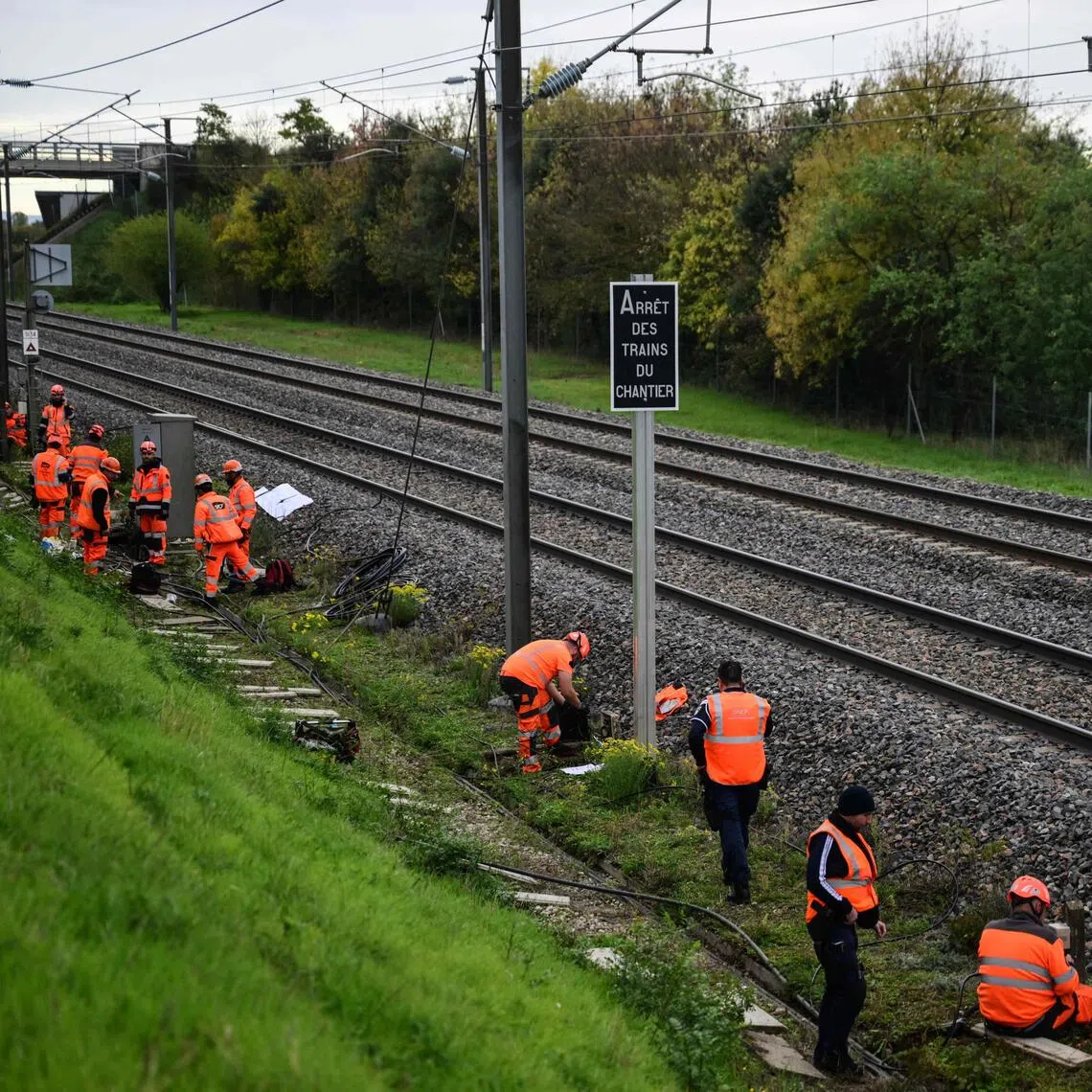 Workmen dealing with charred cables and equipment along a section of railway line affected by arson, south of Valence's TGV railway station, in the south-east of the country, on Oct 27.