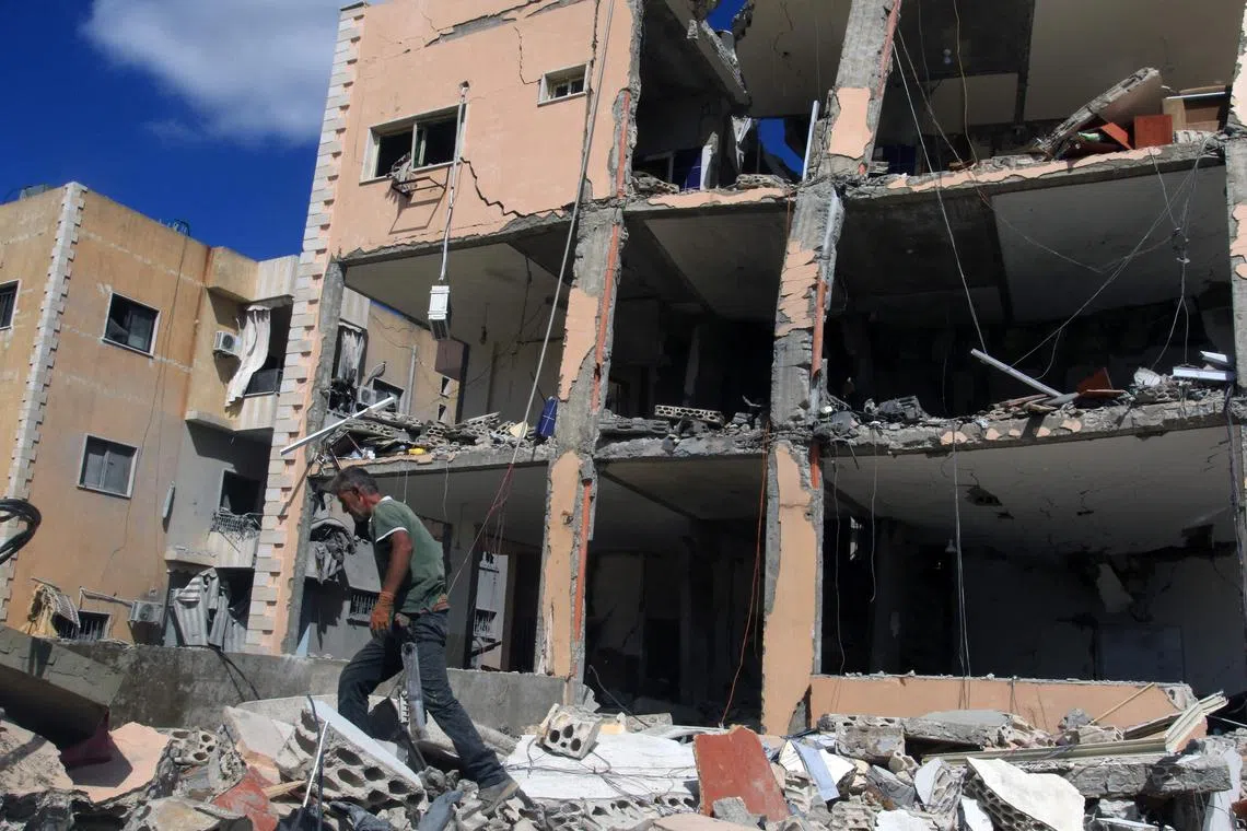 A man walks amid the rubble in front of a building heavily damaged in an overnight Israeli strike in Kfar Rumman, near the southern Lebanese town of Nabatiyeh, on Sept 14. Lebanon's Hezbollah has traded near-daily fire with Israeli forces in support of ally Hamas since the Palestinian militant group's Oct 7 attack triggered the Gaza war. 