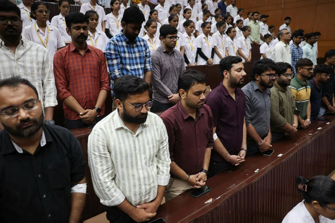 People observe a moment of silence as they attend the memorial ceremony during the first anniversary of Air India Boeing 787-8 Dreamliner crash on June 12, 2025, at B.J. Medical College and Civil hospital in Ahmedabad, India, June 12, 2026. REUTERS/Amit Dave