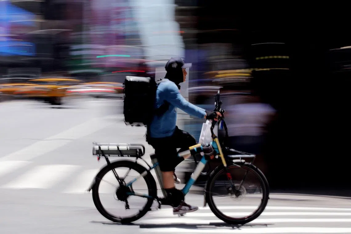A delivery worker rides a bike through Times Square in New York City on June 24, 2025. A potentially life-threatening heat wave enveloped the eastern third of the United States on June 23 impacting nearly 160 million people, with temperatures this week expected to reach 102 degrees Fahrenheit (39 degrees Celsius) in the New York metropolitan area. Dangerously high temperatures are forecast through midweek in Washington, Baltimore, Philadelphia, New York City and Boston. (Photo by Leonardo Munoz / AFP)