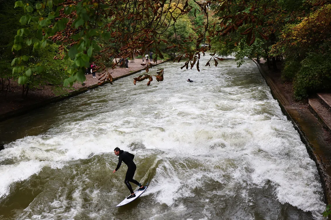 A man surfing at the Eisbach creek at the English garden in Munich Germany, on Oct 7, 2025. 