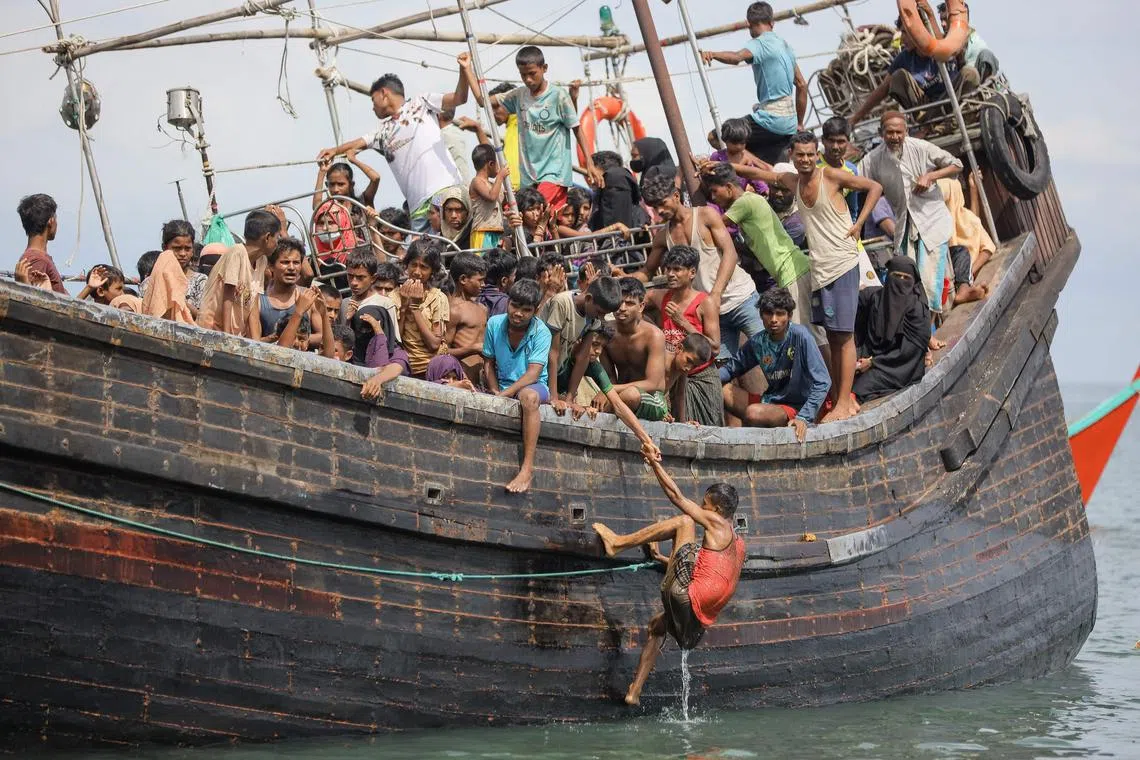 TOPSHOT - Newly arrived Rohingya refugees are stranded on a boat as the nearby community decided not to allow them to land after providing water and food.