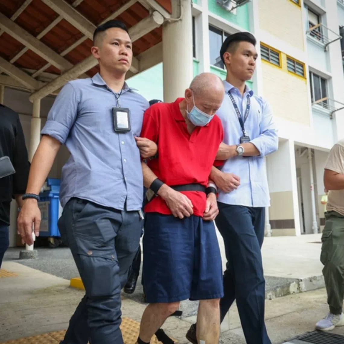 Koh Ah Hwee was in restraints as he was led to his unit on the fifth floor.