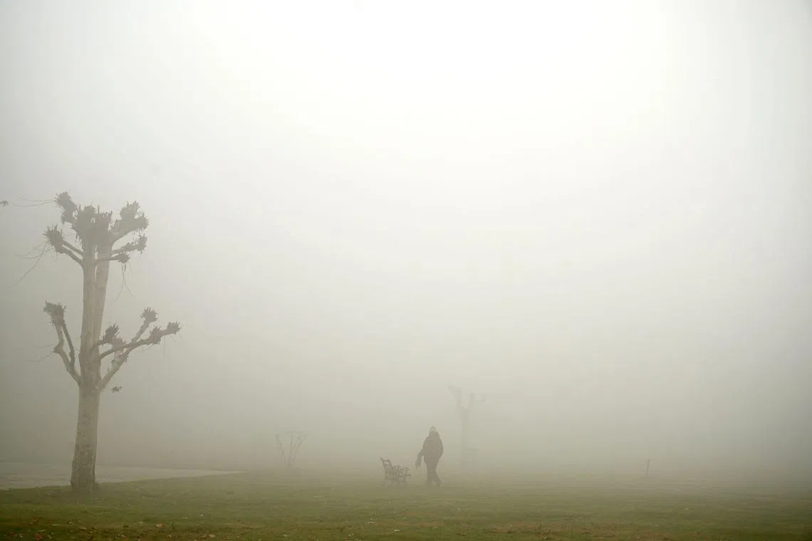 A man walking  at a park amid dense fog in Srinagar on Nov 20, 2023.