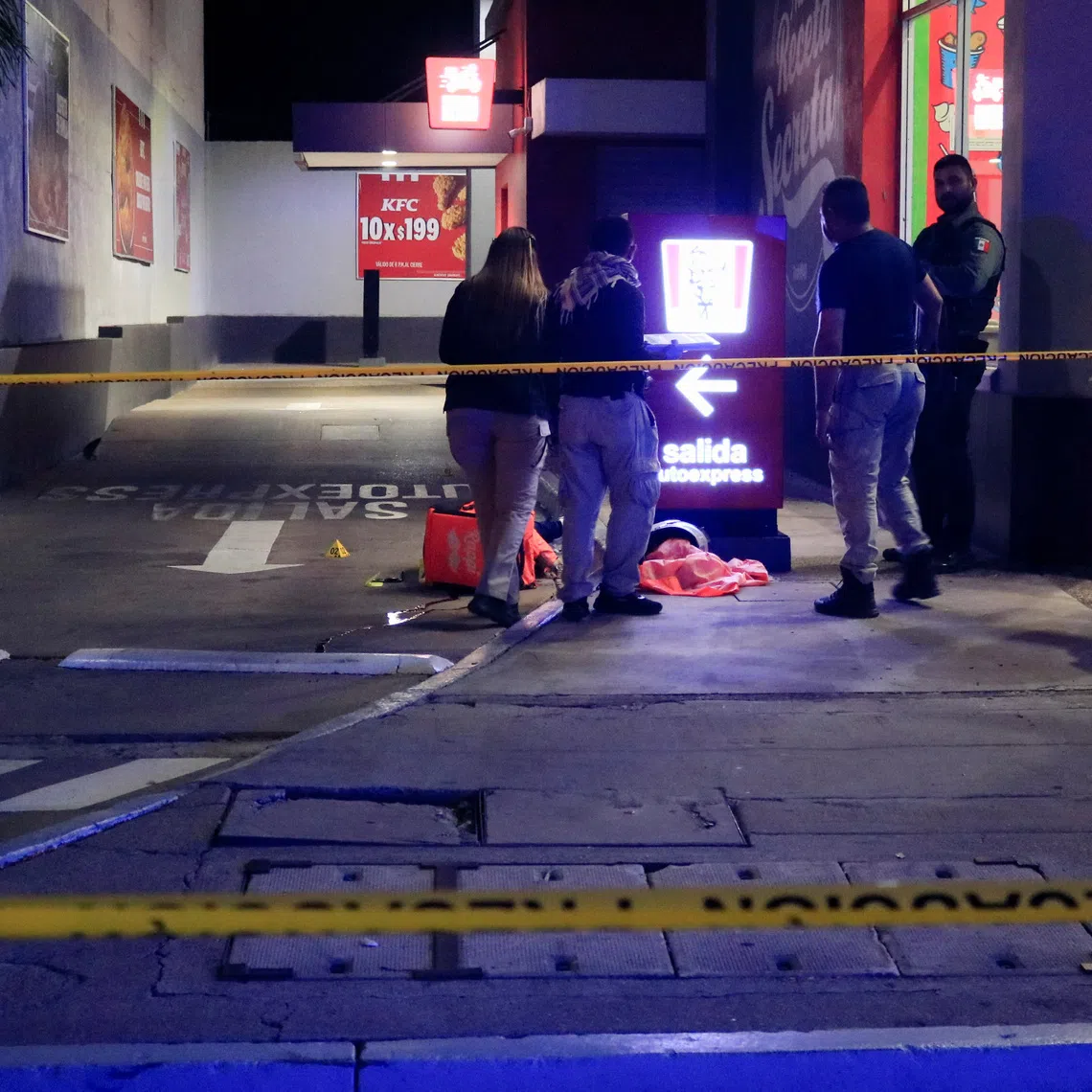 Forensic technicians and police officers work at the crime scene where Mexican social media influencer Cesar Gastelum, known for his comedy videos and followed by nearly 600,000 people on TikTok, was shot and killed while livestreaming with friends outside a fast-food restaurant in Culiacan, Sinaloa state, Mexico, August 4, 2026. REUTERS/Jesus Bustamante