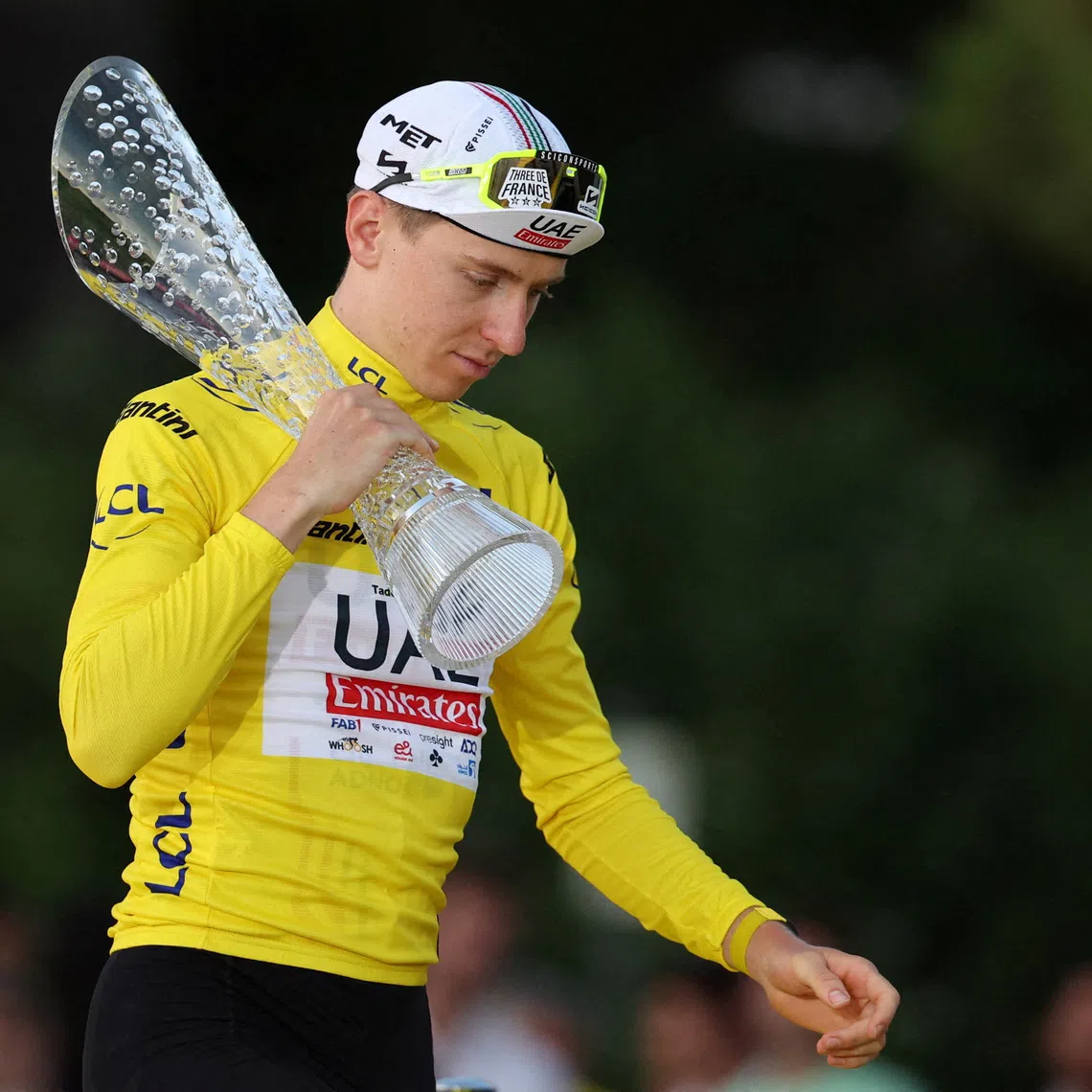FILE PHOTO: Cycling - Tour de France - Stage 21 - Monaco to Nice - Monaco, France - July 21, 2024 UAE Team Emirates' Tadej Pogacar walks onto the podium wearing the yellow jersey with a trophy after winning the Tour de France REUTERS/Manon Cruz/File Photo