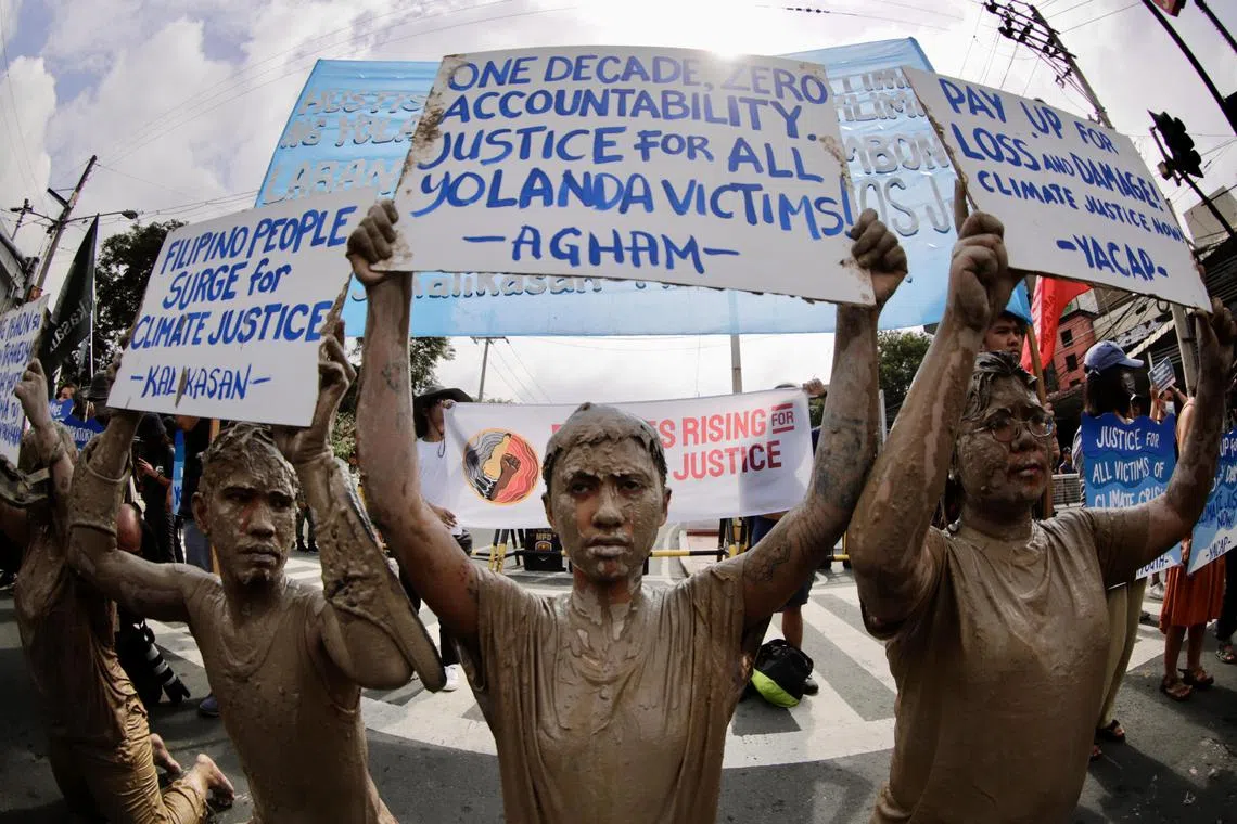 Protesters caked in mud hold a rally to mark the 10th year since Super Typhoon Haiyan tore across central Philippines.