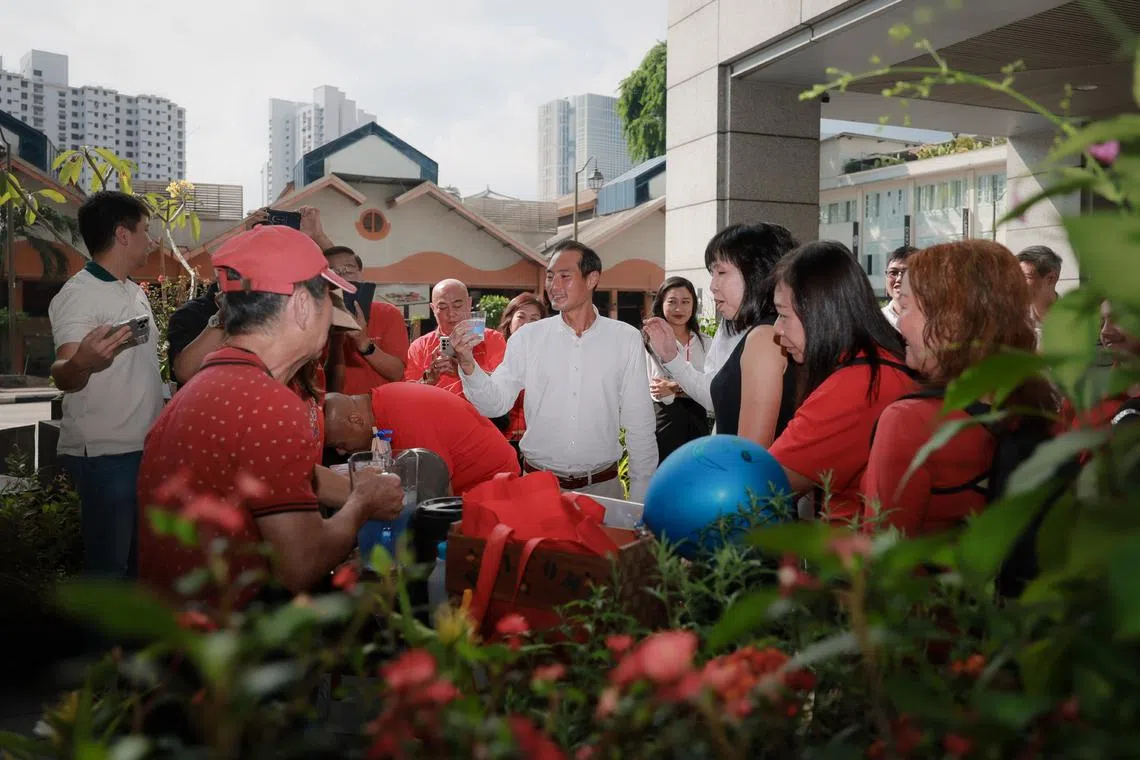 Senior Minister of State for National Development Tan Kiat How having a cup of blue pea tea at the Pelatok Art Farm installation on April 1.