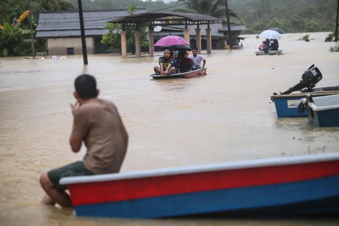 People travelling in boats through a flooded area in Kuala Terengganu, Malaysia, on Dec 21, 2022. 