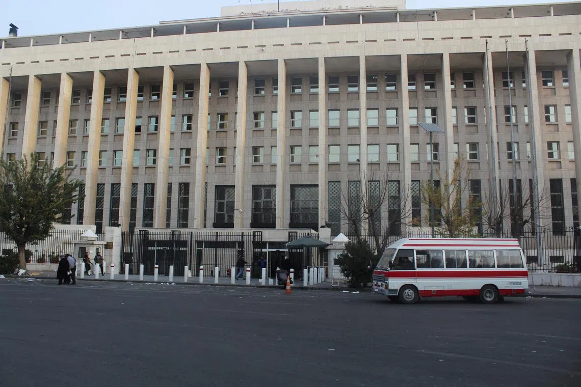 Employees enter the Syrian Central Bank as they return to work, after rebels seized the capital and ousted Syria's Bashar al-Assad, in Damascus, December 10, 2024. REUTERS/Firas Makdesi