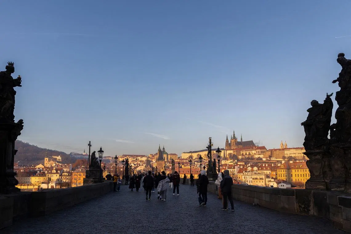 FILE PHOTO: People walk across the medieval Charles Bridge in Prague, Czech Republic, December 26, 2024. REUTERS/Eva Korinkova/ File Photo