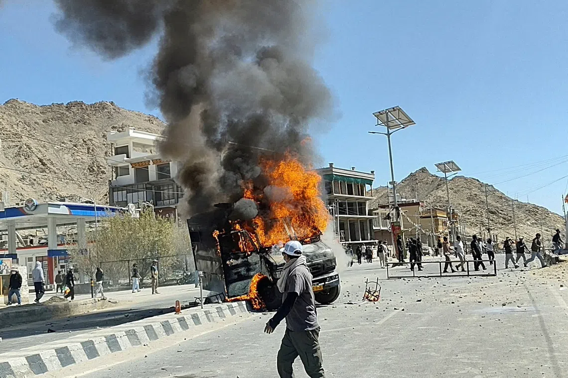 A vehicle is set on fire during a protest by locals demanding statehood for the federal territory and job quotas for local residents in Leh, in the Ladakh region, India, September 24, 2025. REUTERS/Stringer