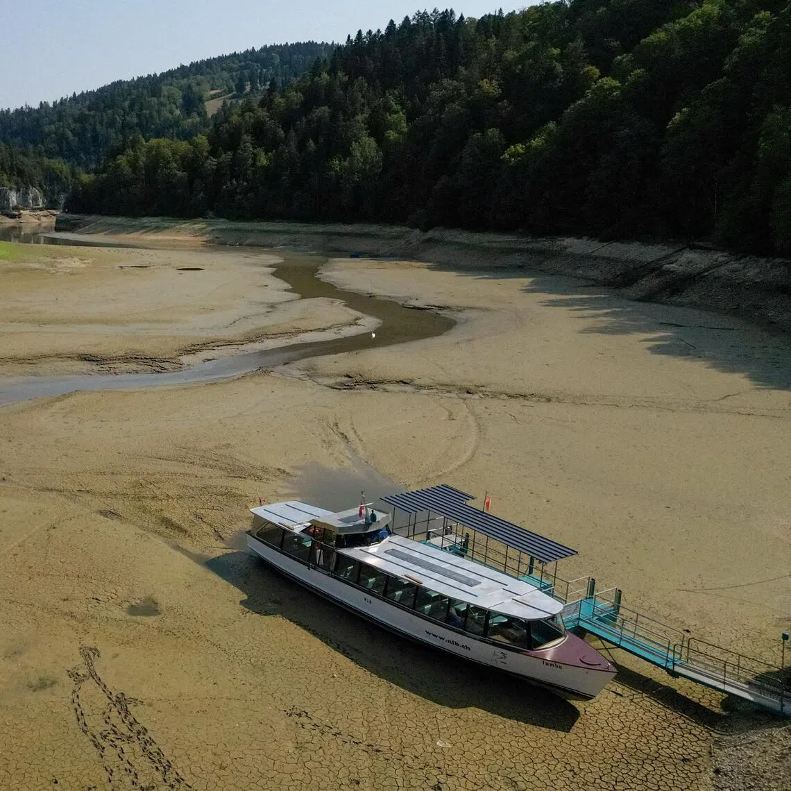A drone view shows a moored boat on the nearly empty Lake Brenets as drought conditions affect the Doubs River lower water levels along the Swiss-French border in Les Brenets, Switzerland, July 30.