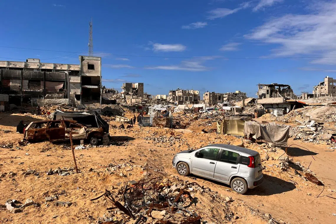 Palestinians walk through a damaged site amid the Israel-Hamas conflict, in Khan Younis, southern Gaza Strip November 27, 2024. REUTERS/Hussam Al-Masri