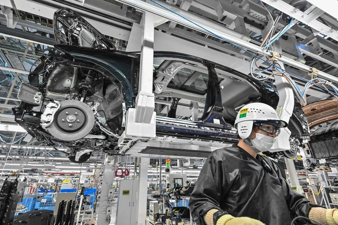 This photo taken on December 8, 2023 shows a worker on the production line during a media tour of the "Nissan Intelligent Factory" at the Nissan Motor Tochigi plant, the company's largest in Japan, in Kaminokawa, Tochigi prefecture, some 105 kms (65 miles) north of Tokyo. (Photo by Richard A. Brooks / AFP)