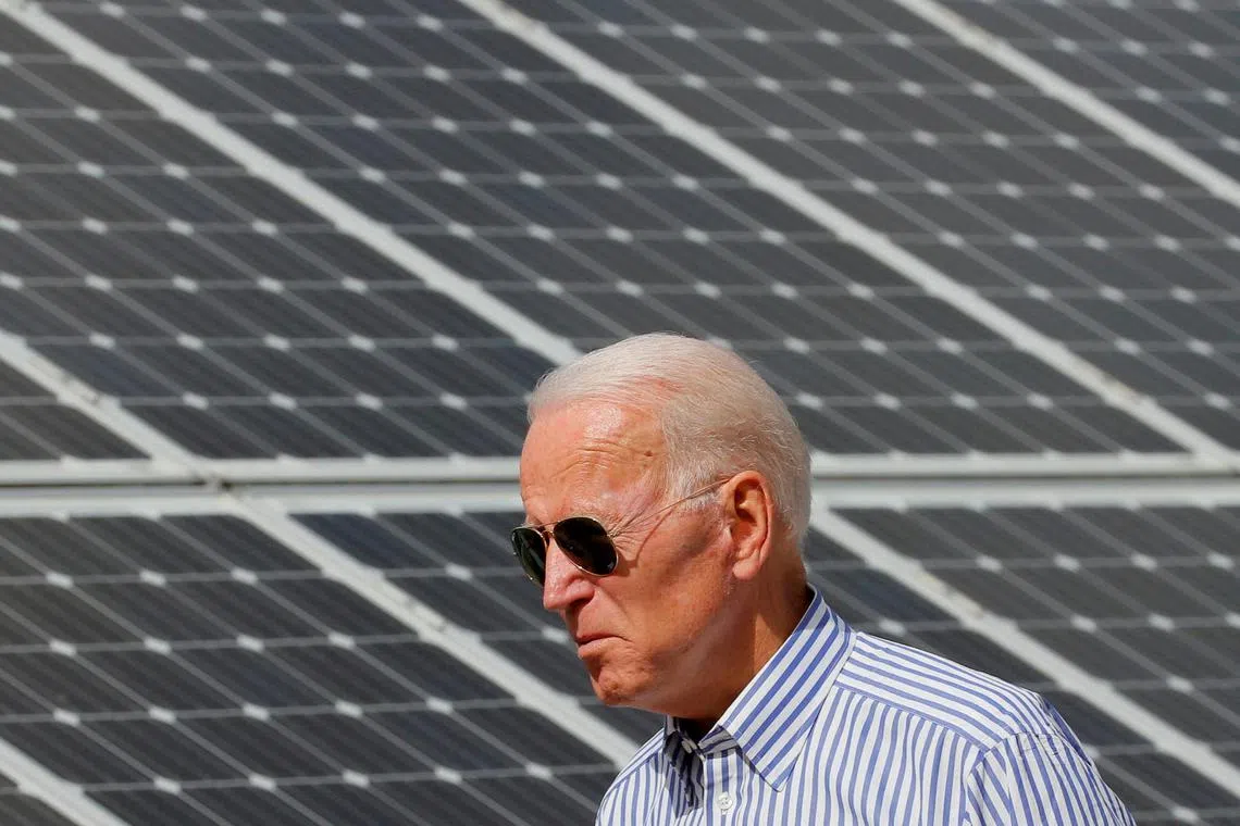 A file photo of US President Joe Biden walking past solar panels while touring the Plymouth Area Renewable Energy Initiative in Plymouth, New Hampshire, US.