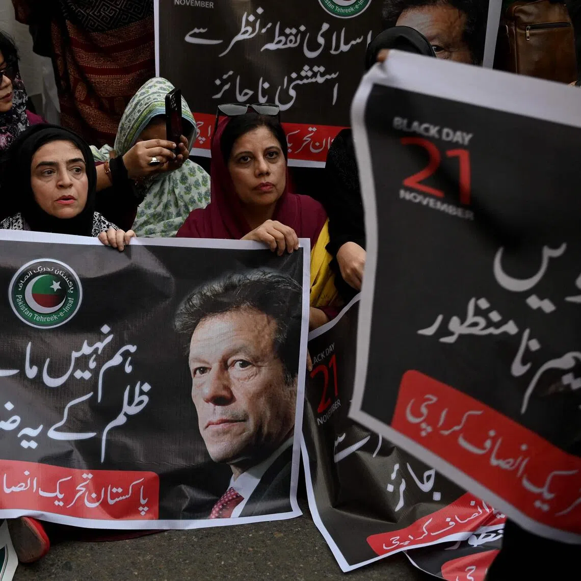 Pakistan Tehreek-e-Insaf party supporters carry a poster of their leader and former prime minister Imran Khan, during a protest against the 27th constitutional amendment, in Karachi on Nov 21. 