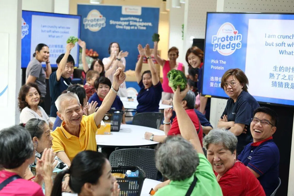 Asian seniors learning more about healthy nutrition, holding up broccoli 