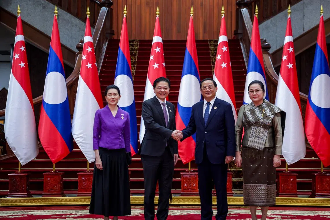 PM Lawrence Wong (second from left) and his Laotian counterpart, Mr Sonexay Siphandone, accompanied by their spouses, meeting in Vientiane on Oct 11.