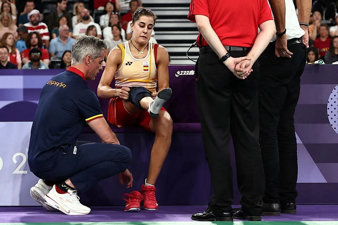 FILE PHOTO: Paris 2024 Olympics - Badminton - Women's Singles Semifinals - Porte de La Chapelle Arena, Paris, France - August 04, 2024. Carolina Marin of Spain is attended to by coaching staff during the match against Bing Jiao He of China. REUTERS/Ann Wang/File Photo