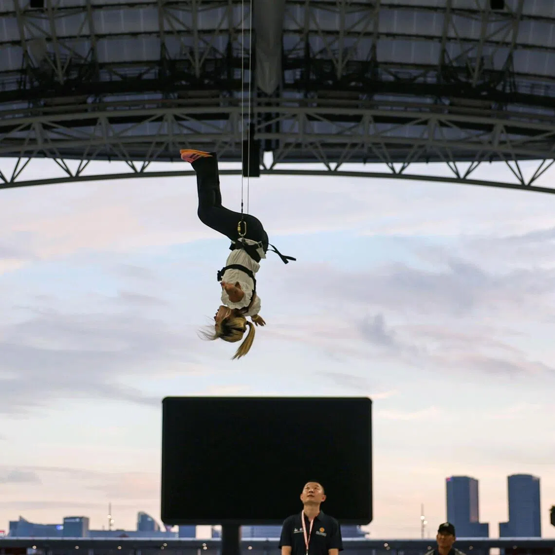 ST journalist Gabrielle Chan attempting the aerial experience during the NDP aerial performance media feature at the National Stadium on July 6.