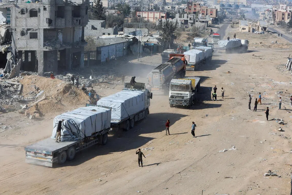 FILE PHOTO: Palestinians gather near trucks carrying aid, following a ceasefire between Israel and Hamas, in Rafah in the southern Gaza Strip, January 21, 2025. REUTERS/Mohammed Salem/File Photo