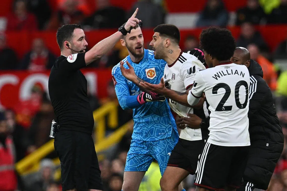 Fulham's Aleksandar Mitrovic (centre) is restrained by Manchester United goalkeeper David de Gea, Fulham's Willian and Fulham assistant coach Luis Boa Morte after being shown a red card by English referee Chris Kavanagh during the FA Cup quarter-final.