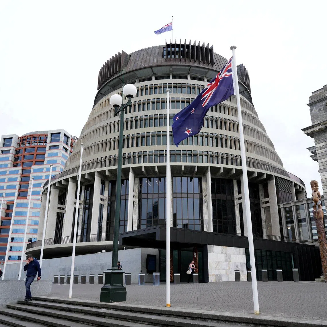FILE PHOTO: New Zealand's flag flutters in front of 'The Beehive', the executive wing of the New Zealand Parliament Buildings, in Wellington, New Zealand, September 24, 2025. REUTERS/Marty Melville/File Photo