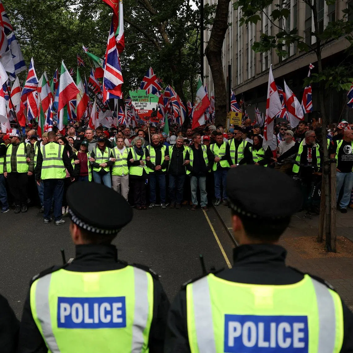 Police officers stand guard as protesters gather for the "Unite the Kingdom" rally, organised by far-right activist Tommy Robinson, in London on May 16.