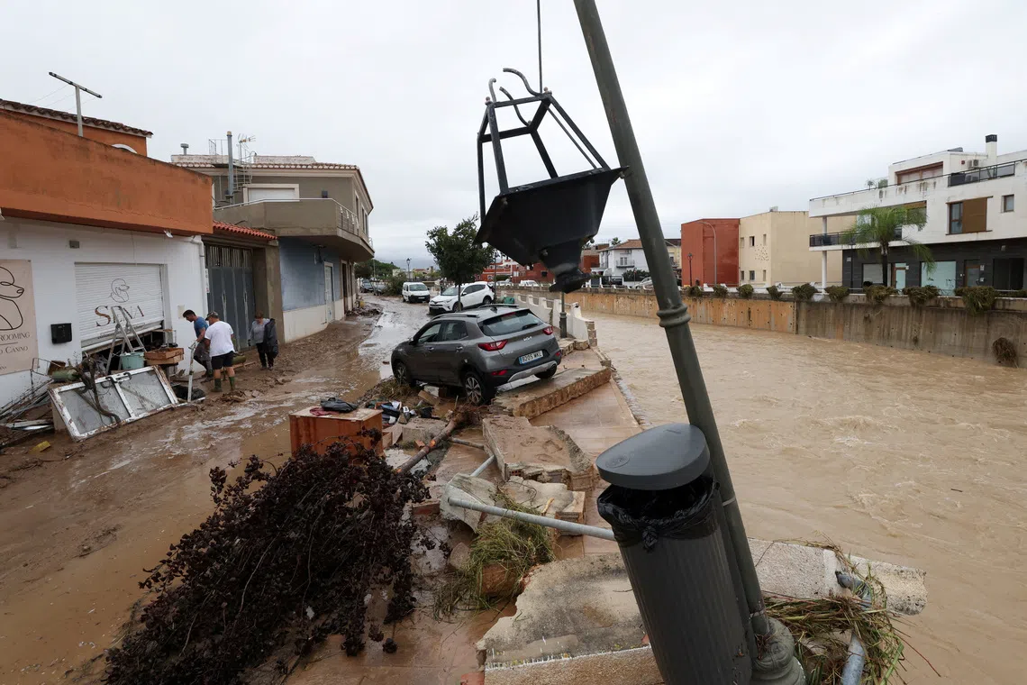 A car on the damaged bank of a waterway, following torrential rains, which caused floods in eastern Spain, in Els Poblets, Spain, October 19, 2026. REUTERS/Eva Manez