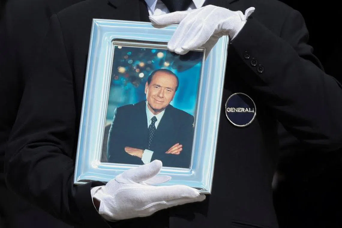 A pallbearer holds a portrait of former Italian Prime Minister Silvio Berlusconi while walking in front of the coffin during his state funeral at the Duomo Cathedral, in Milan, Italy June 14, 2023. REUTERS/Yara Nardi