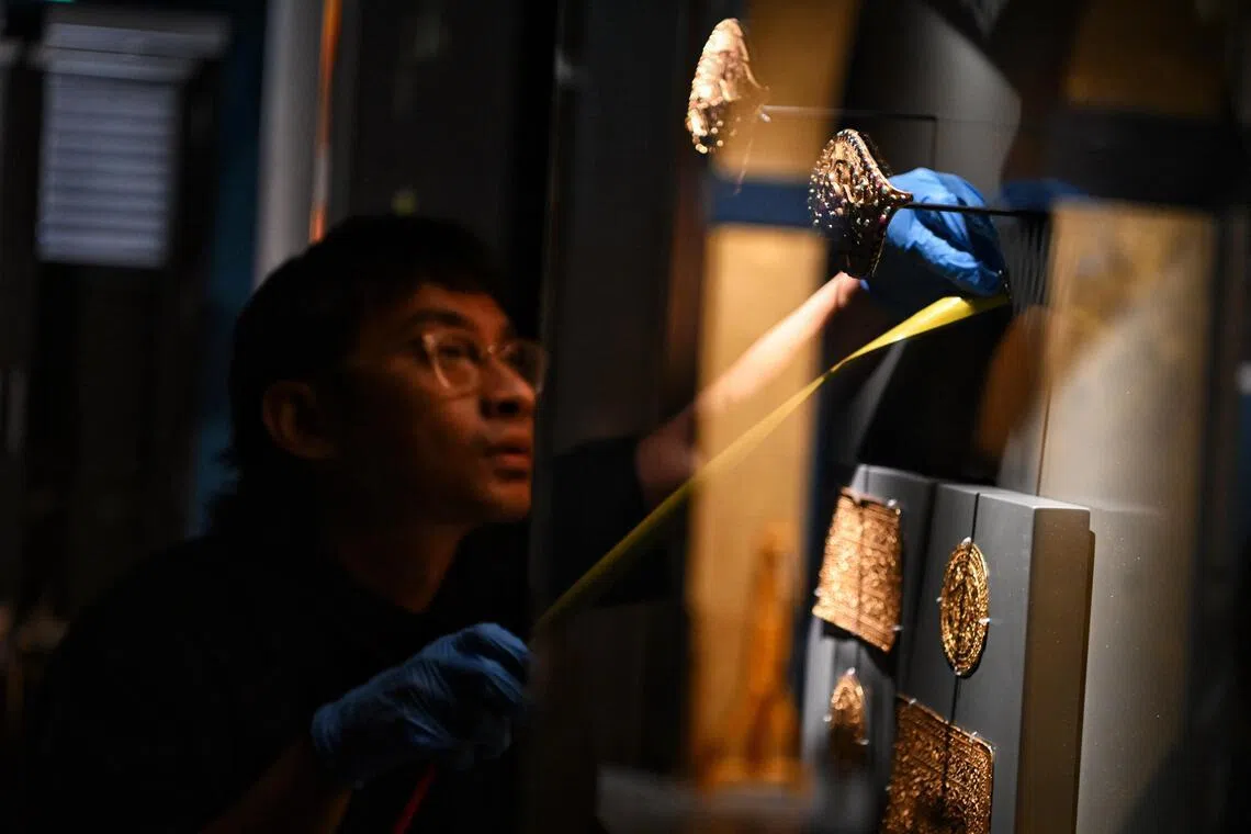 Mr Muhammad Noor Aliff, assistant director for collections and exhibitions at heritage institutions under the National Heritage Board, installing pendings, or buckles, with semi-precious stones at the gallery of the Malay Heritage Centre on Feb 3.