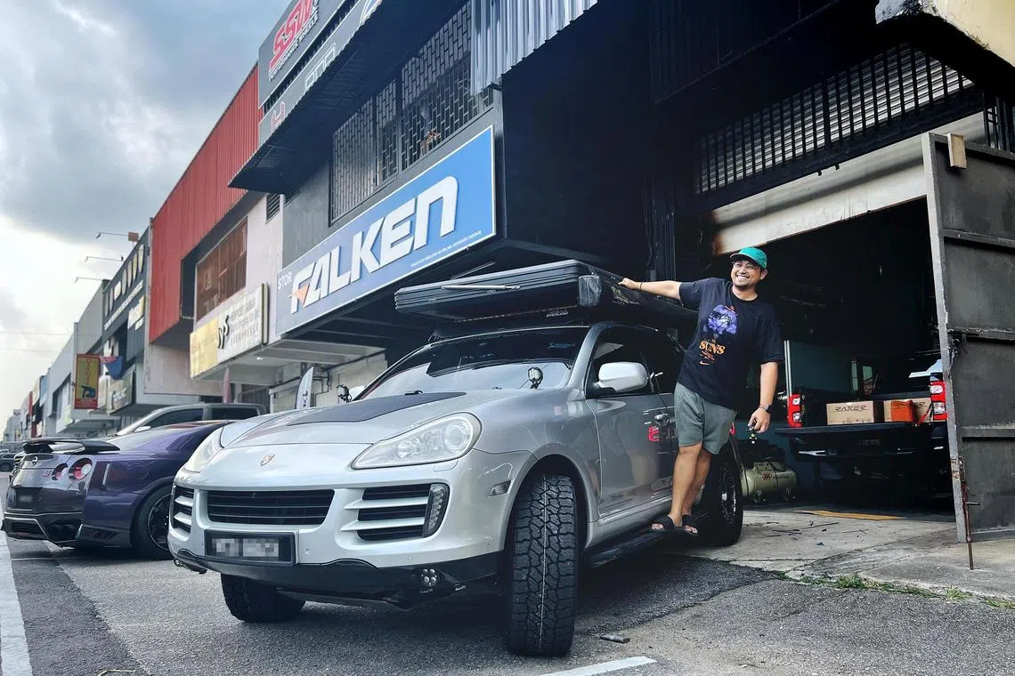 Mr Iylia Kwan, posing with his Malaysian-registered 2009 Porsche Cayenne SUV, which he bought secondhand for RM50,000 (S$15,000) in 2022.
