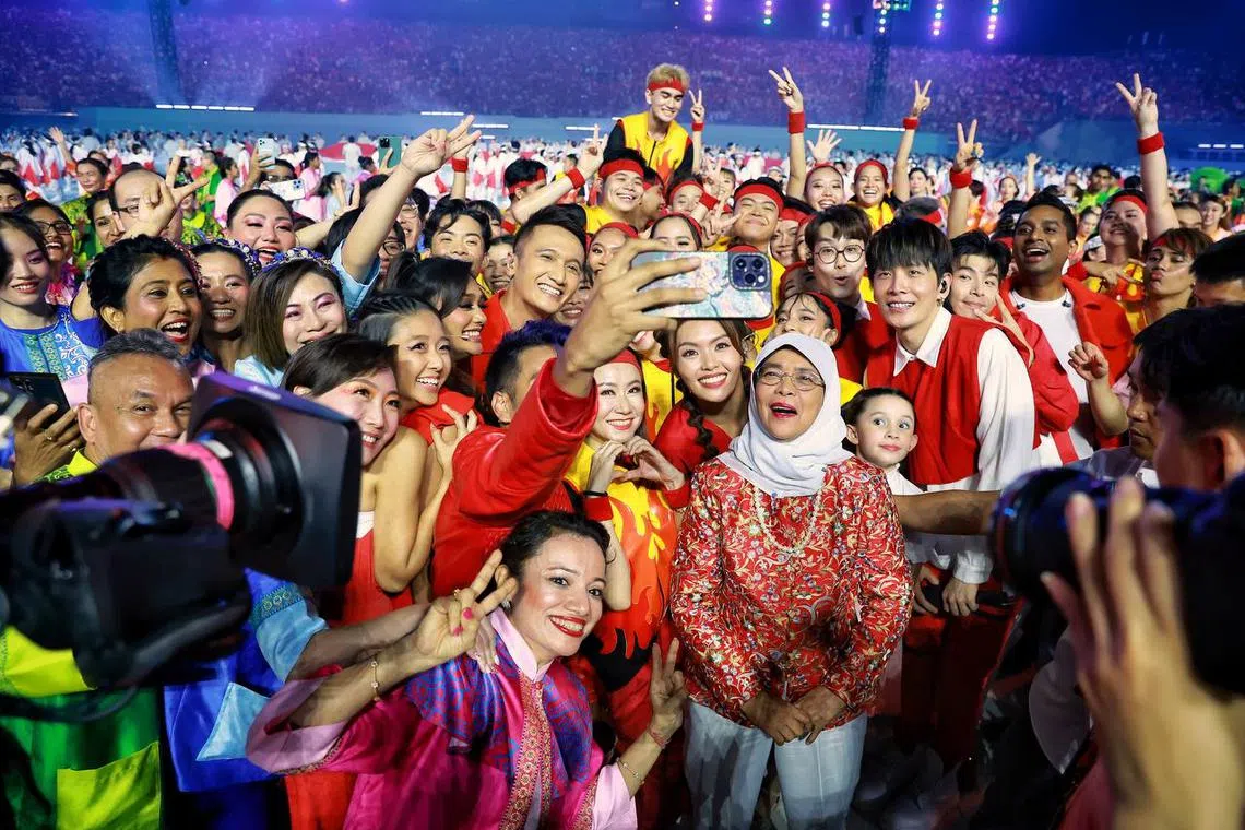 President Halimah Yacob taking a wefie with National Day Parade hosts and performers.