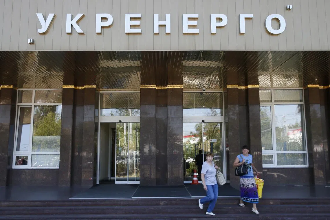 FILE PHOTO: Women walk outside the headquarters of Ukrainian state power distributor Ukrenergo in Kiev, Ukraine June 30, 2017. REUTERS/Valentyn Ogirenko/File Photo