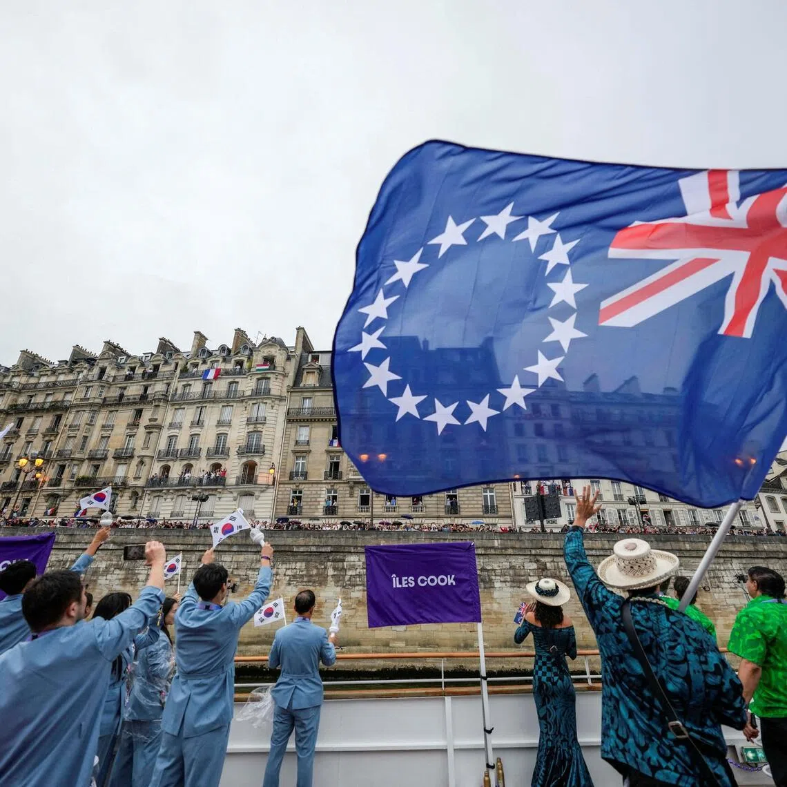 FILE PHOTO: Paris 2024 Olympics - Opening Ceremony - Paris, France - July 26, 2024. Team South Korea and Team Cook Islands wave their flags from a boat during the opening ceremony of the 2024 Summer Olympics.   Lee Jin-man/Pool via REUTERS/File Photo