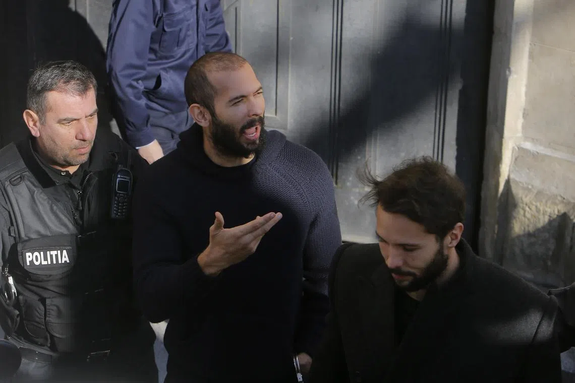 Former professional kickboxer and social media influencer Andrew Tate (centre) and brother Tristan Tate (right) are escorted by police officers after a court hearing in Bucharest.